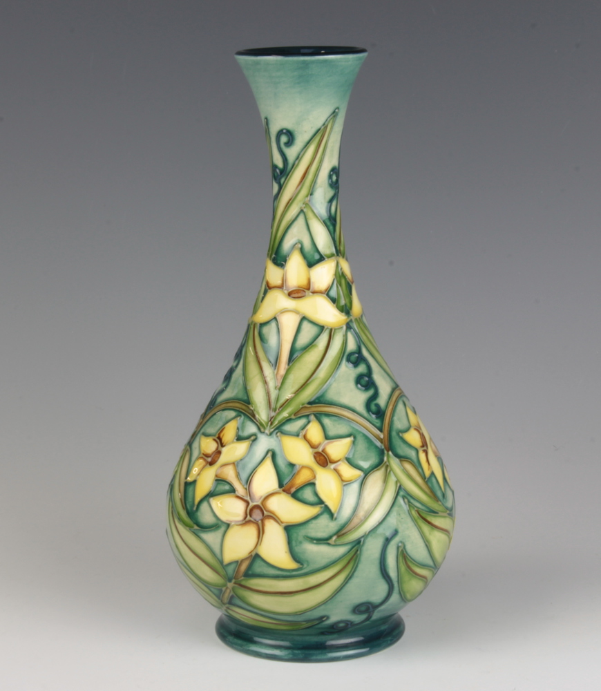 A modern Moorcroft bottle vase, the green ground decorated with daffodils with impressed and printed