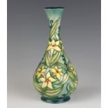 A modern Moorcroft bottle vase, the green ground decorated with daffodils with impressed and printed