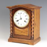 A Wurtemberg striking mantel clock with enamelled dial and Roman numerals contained in an oak arch