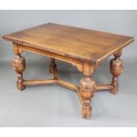 An oak draw leaf dining table, raised on carved cup and cover supports with Y shaped stretcher