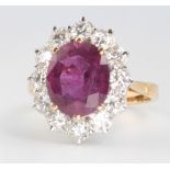 An 18ct yellow gold oval ruby and diamond cluster ring, the centre stone approx. 4ct surrounded by