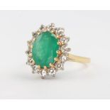 An 18ct yellow gold emerald and diamond oval cluster ring, the centre oval stone approx. 4ct