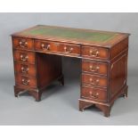 A Victorian style mahogany kneehole pedestal desk with inset green leather writing surface fitted