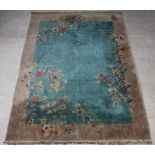 A 1930's green ground and floral patterned Chinese carpet 361cm x 270cm Some staining in places