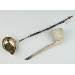 An 18th Century silver coin set ladle with whalebone handle together with a clay pipe The ladle