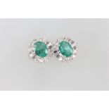 A pair of 18ct white gold emerald and diamond cluster earrings, the emeralds approx. 2.07ct