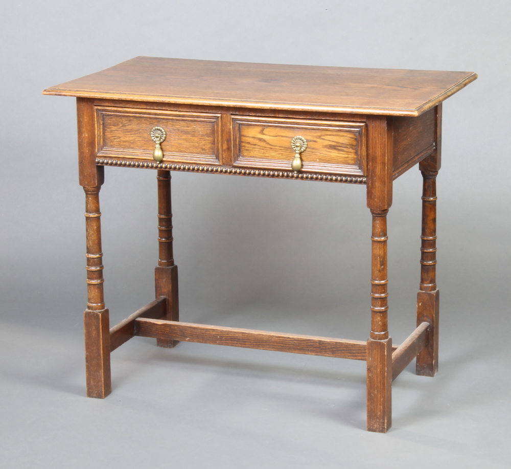 An 18th Century style oak side table with geometric moulding fitted 2 short drawers with pear drop