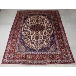 A red, blue and white ground Persian Isfahan carpet with central medallion within multi-row border