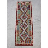 A multi coloured wool Kilim runner with geometric designs 202cm x 66cm