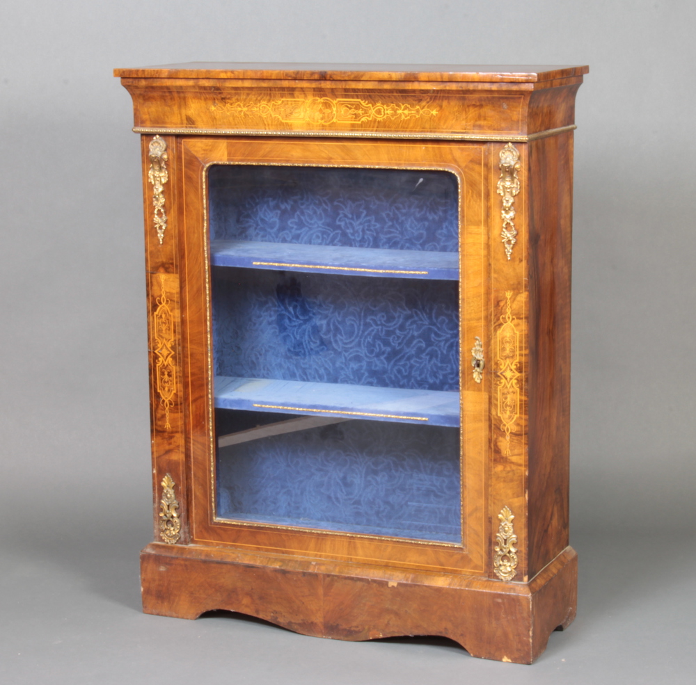 A Victorian inlaid figured walnut pier cabinet with gilt metal mounts enclosed by a glazed