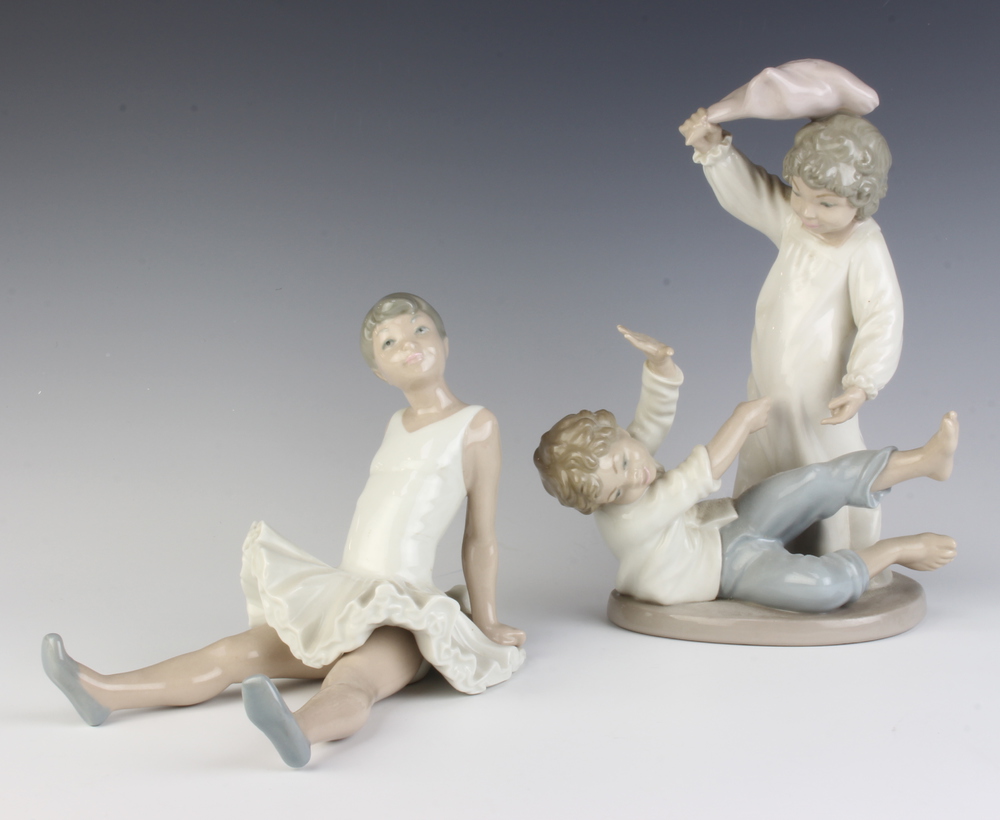 A Nao figure of a seated ballerina 17cm, ditto of two boys playing 24cm