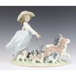 A Lladro figure of a young lady holding 2 spaniels on leads with 5 puppies no.6784 22cm, boxed