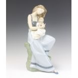 A Nao figure of a lady holding a young girl seated on a rocky outcrop no.1297, 37cm