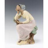 A Lladro matt figure of a seated lady on a tree trunk 31cm The figure is missing her book