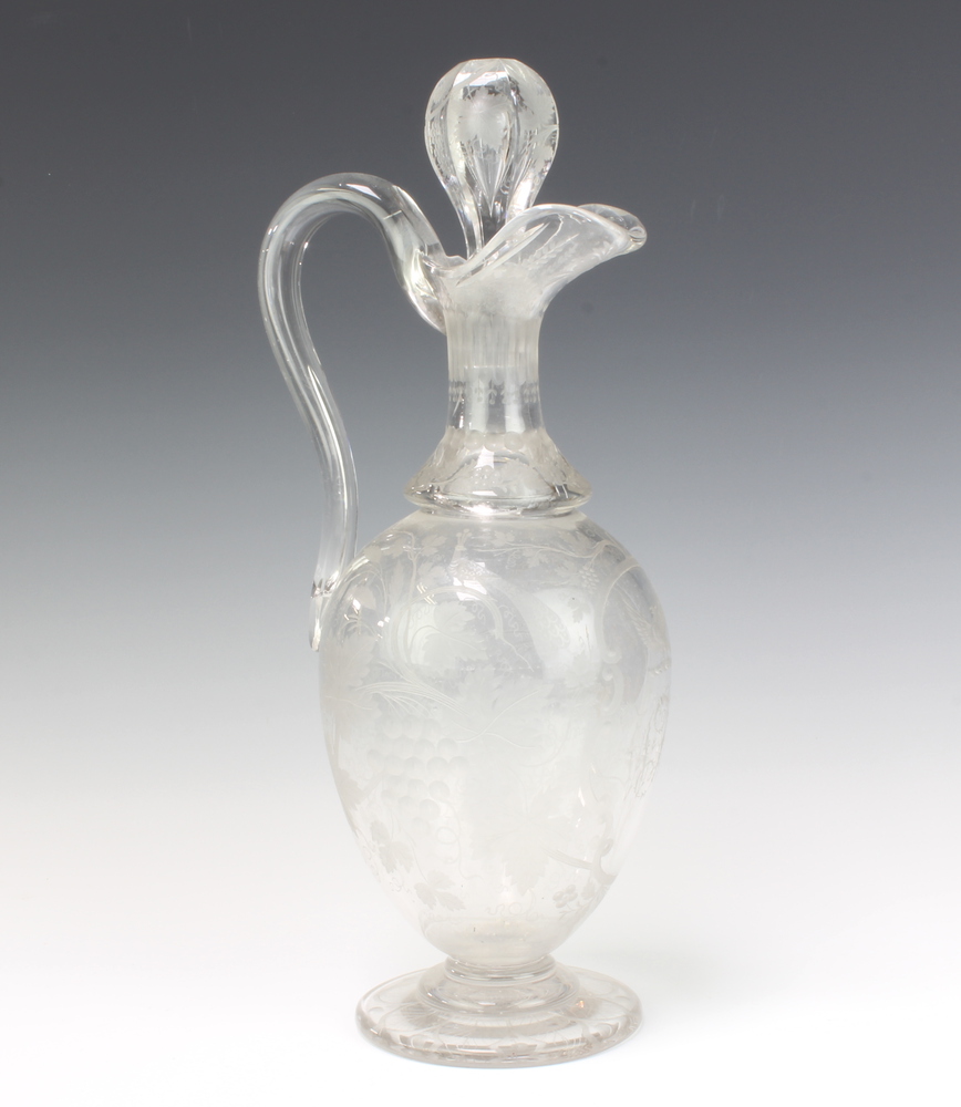 A good Edwardian cut glass bulbous ewer and stopper, extensively decorated with scrolling vines,