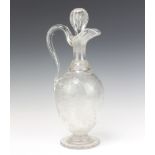 A good Edwardian cut glass bulbous ewer and stopper, extensively decorated with scrolling vines,