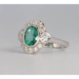 An 18ct white gold oval emerald and diamond cluster ring, the centre stone approx. 1.5ct