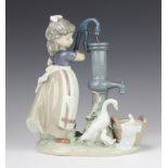 A Lladro figure of a girl at a water pump with a family of geese at her feet 23cm The pump handle is