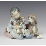 A Lladro group of a boy with a dog and puppies 5456 11cm