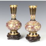 A pair of Japanese cloisonne enamelled club shaped vases raised on pierced hardwood stands 21cm h