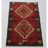 A brown and black ground Belouche rug with 2 stylised diamonds to the centre 145cm x 88cm