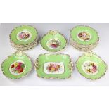An Edwardian Copeland dessert service with green and gilt rims enclosing painted floral sprays,