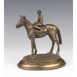 A bronzed figure of a race horse with jockey up, raised on an oval base 15cm h