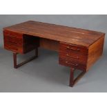 Mid Century, a rosewood finished desk fitted 6 drawers and a recess, raised on square supports