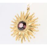 A 9ct yellow gold star shaped garnet set pendant, 3.4 grams gross, 24mm