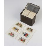 A small collection of cigarette cards contained in a metal tin, mostly Wills