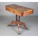 A Regency mahogany D shaped card table raised on 2 turned columns with platform base and splayed