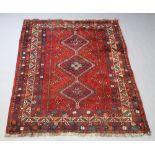 A red and blue ground Afghan rug with 3 diamonds to the centre within a multi row border 231cm x