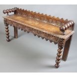 A Victorian carved oak hall bench with raised back and carved apron, raised on bobbin turned