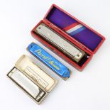 The M Hohner Super Chromatic harmonica boxed, a ditto Blues Band and a Parrot harmonica