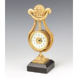 A French timepiece with enamelled dial and Arabic numerals contained in a gilt metal lyre shaped