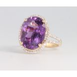 A 14ct yellow gold oval cut amethyst and diamond cluster ring, the centre stone approx. 6.92ct