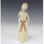 A Lladro figure of a young lady holding a bonnet behind her no. 5006 24cm