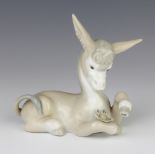 A Lladro figure of a reclining donkey with love me, love me not daisy in Spanish 11cm