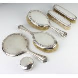 A silver backed dressing table set comprising hand mirror, 2 hair brushes, 2 clothes brushes,