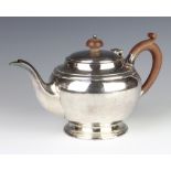 A silver bulbous bodied teapot with fruitwood handles London 1933, gross 553 grams,