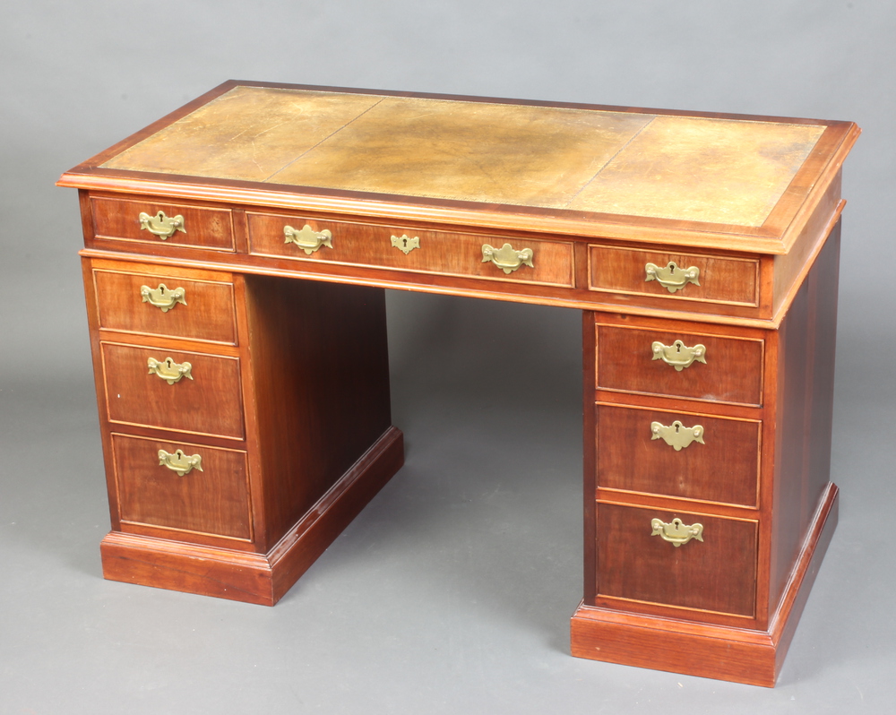 A mahogany kneehole pedestal desk with green inset leather writing surface, above 1 long and 8 short