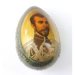 A Russian painted and lacquered egg decorated a portrait of Tsar Nicholas II 9cm x 5cm There is some