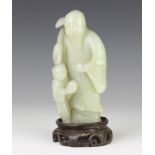 A jade figure of Shou Lao, c1900, the figure in grey-green stone standing holding a ru-i sceptre