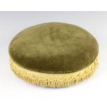 A Victorian circular footstool upholstered in green dralon, raised on 3 bun feet 9cm h x 35cm diam.