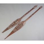 Two African carved Niger paddles 144cm l x 13cm w One has a damaged tip and both have damaged base