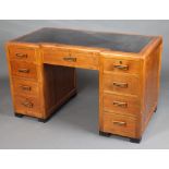 A 1930's Art Deco mahogany inverted breakfront desk with black tooled leather writing surface,