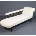 A Victorian mahogany chaise longue with bobbin turned decoration upholstered in white material,