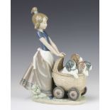 A Lladro group of a young girl pushing a pram of puppies 5364 21cm