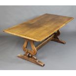 A 17th Century style light elm refectory dining table raised on lyre shaped supports with H framed