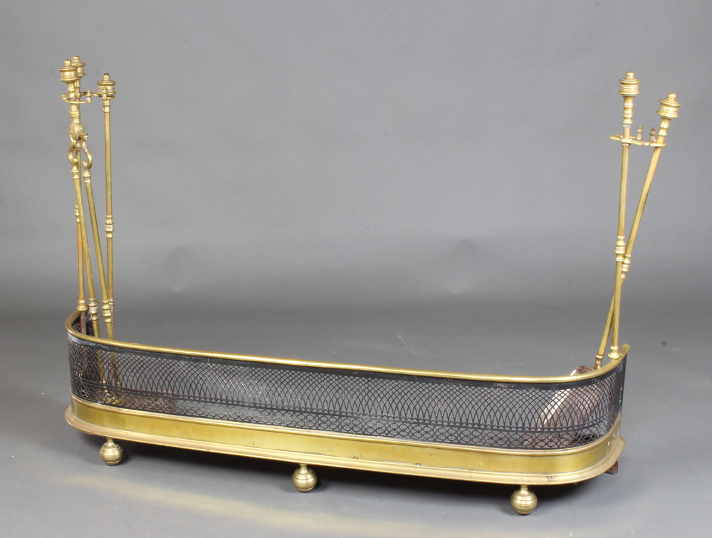 A Victorian brass and pierced steel fender, the sides fitted removable associated companion stands